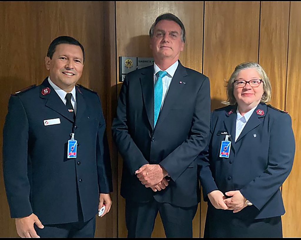 PHOTO CAPTION: Majors Isaias (left) and Adelma Braga flank Brazil's President Jair Bolsonaro.